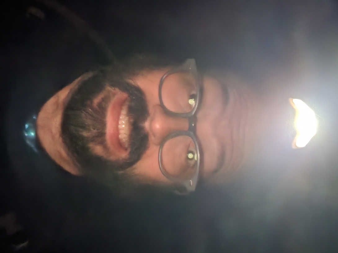 Adam smiles into the camera beneath his glowing headlamp at the Cascade and Porter trailhead shortly after 4 a.m.