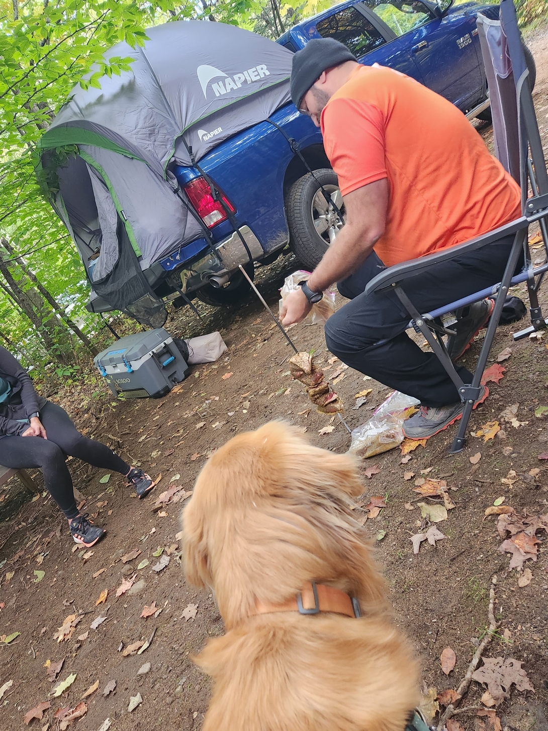 Sunny watches Mr. John prepare food beside the open car at Draper’s Acres Campground.