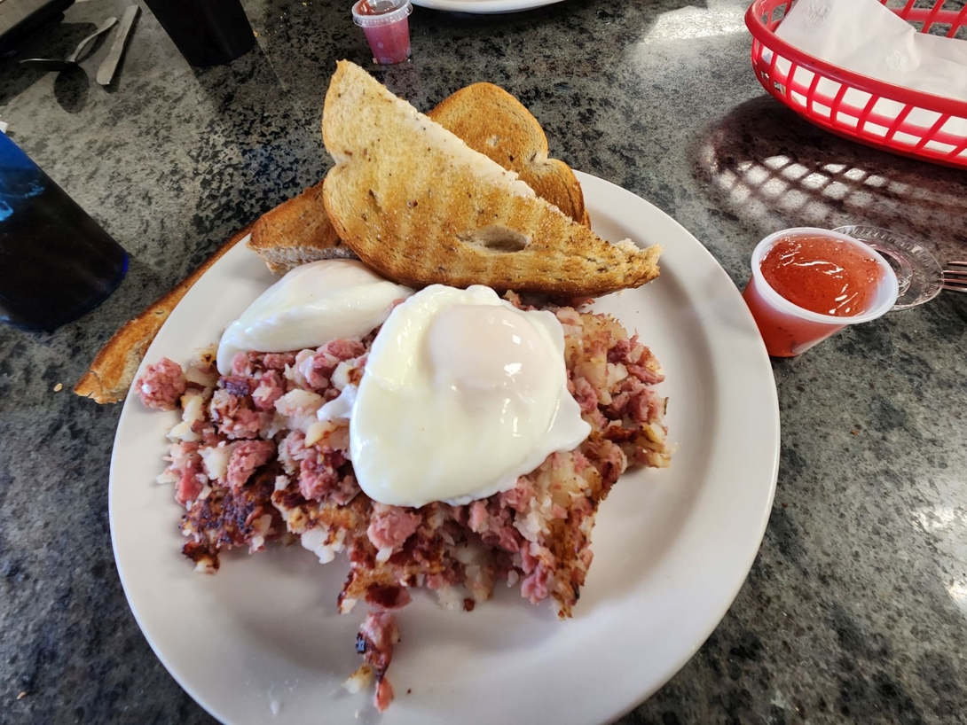 Corned beef hash topped with eggs and served with toast at Noon Mark Diner after the winter hike.